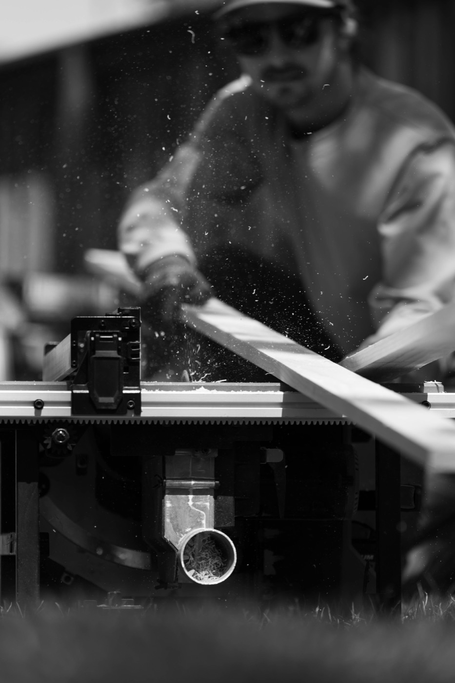 Sawdust flying as a board is cut on a table saw while the Hatti pop-up cart is built