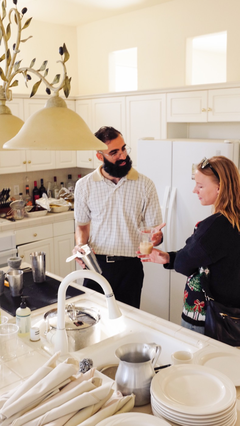 A glass of chai handed across a kitchen counter to a guest at a Hatti pop-up