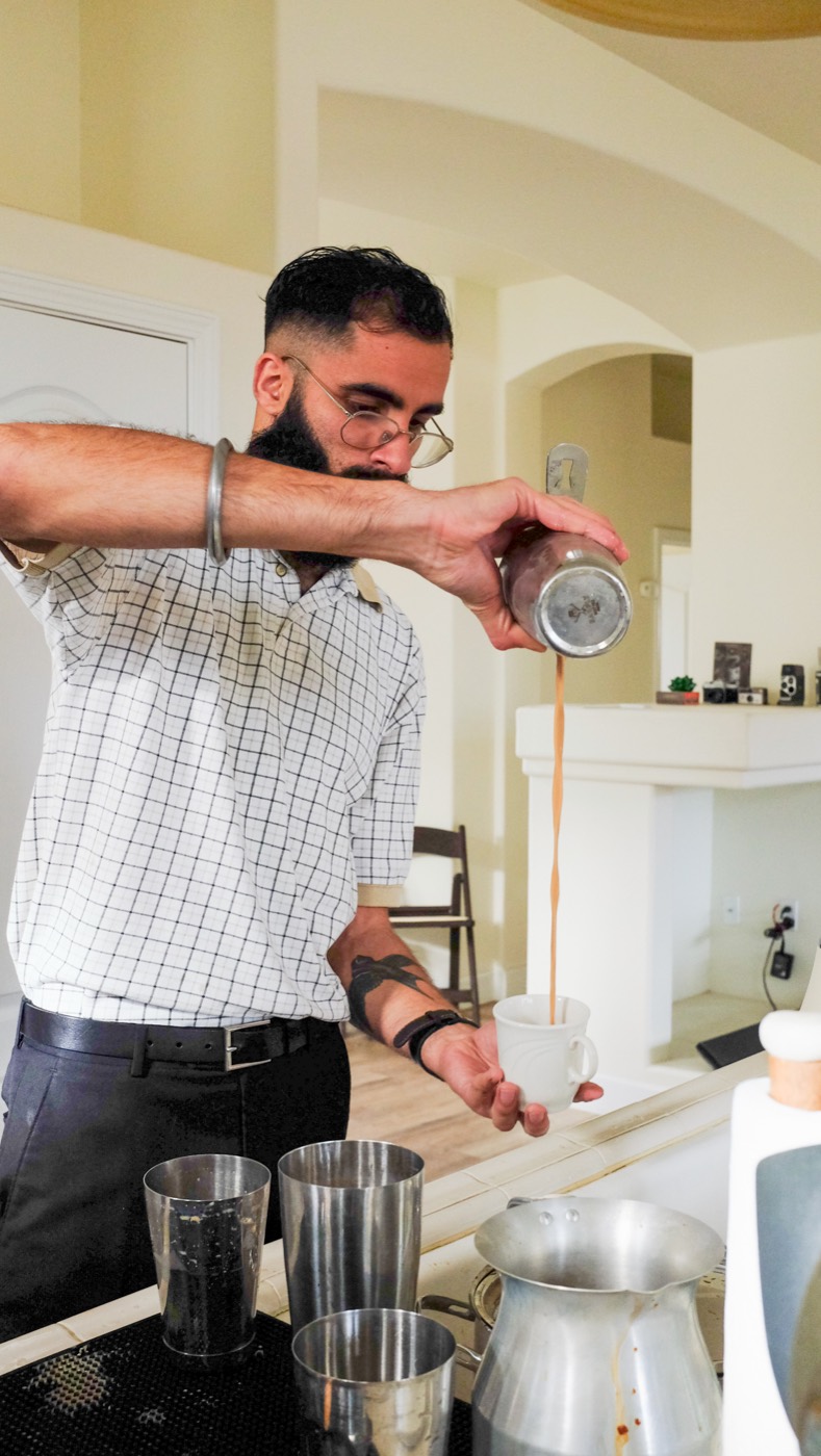 Chai poured in a long stream from a steel pan into a cup at a Hatti pop-up