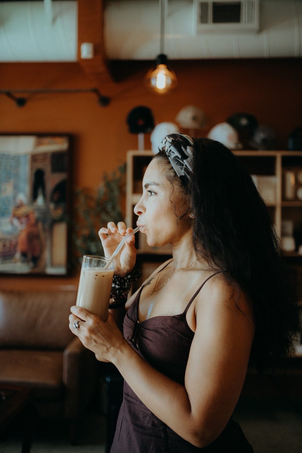 A woman drinking iced chai through a straw at a Hatti pop-up